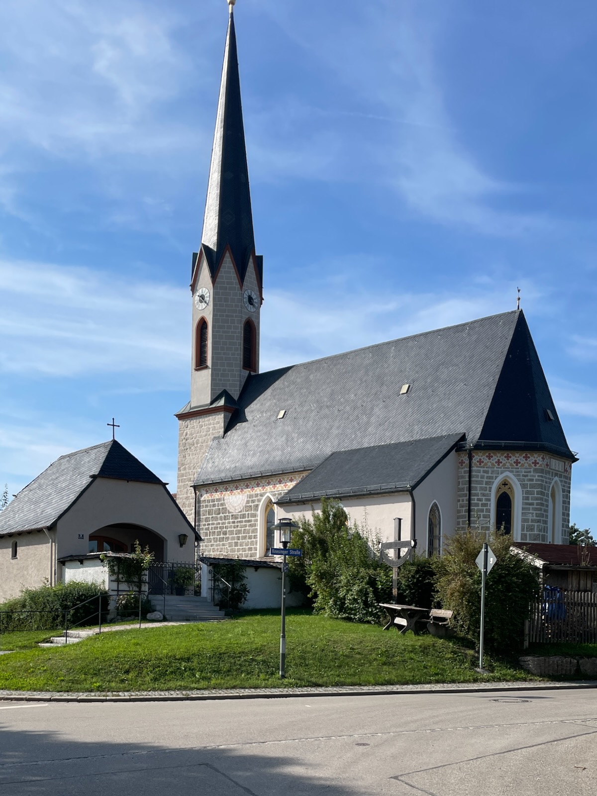 Pfarrkirche St. Laurentius in Hart bei Chieming mit hohem Spitzhelm und neugotischen Elementen, seitliche Außenansicht