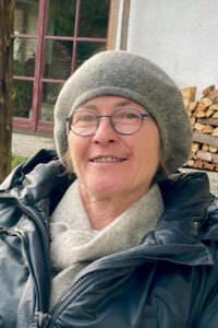 Porträt der Künstlerin Angelika Gimpl mit grauer Mütze und Brille