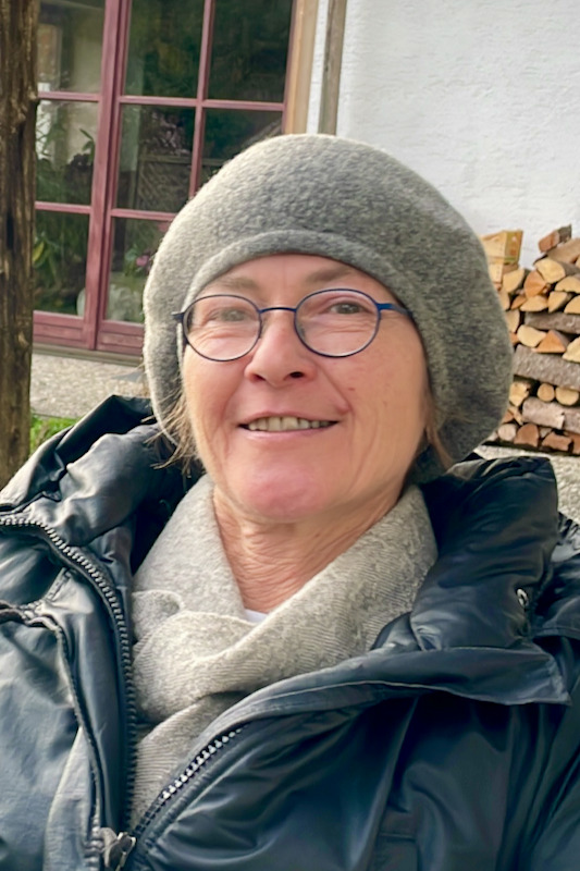 Porträt der Künstlerin Angelika Gimpl mit grauer Mütze und Brille